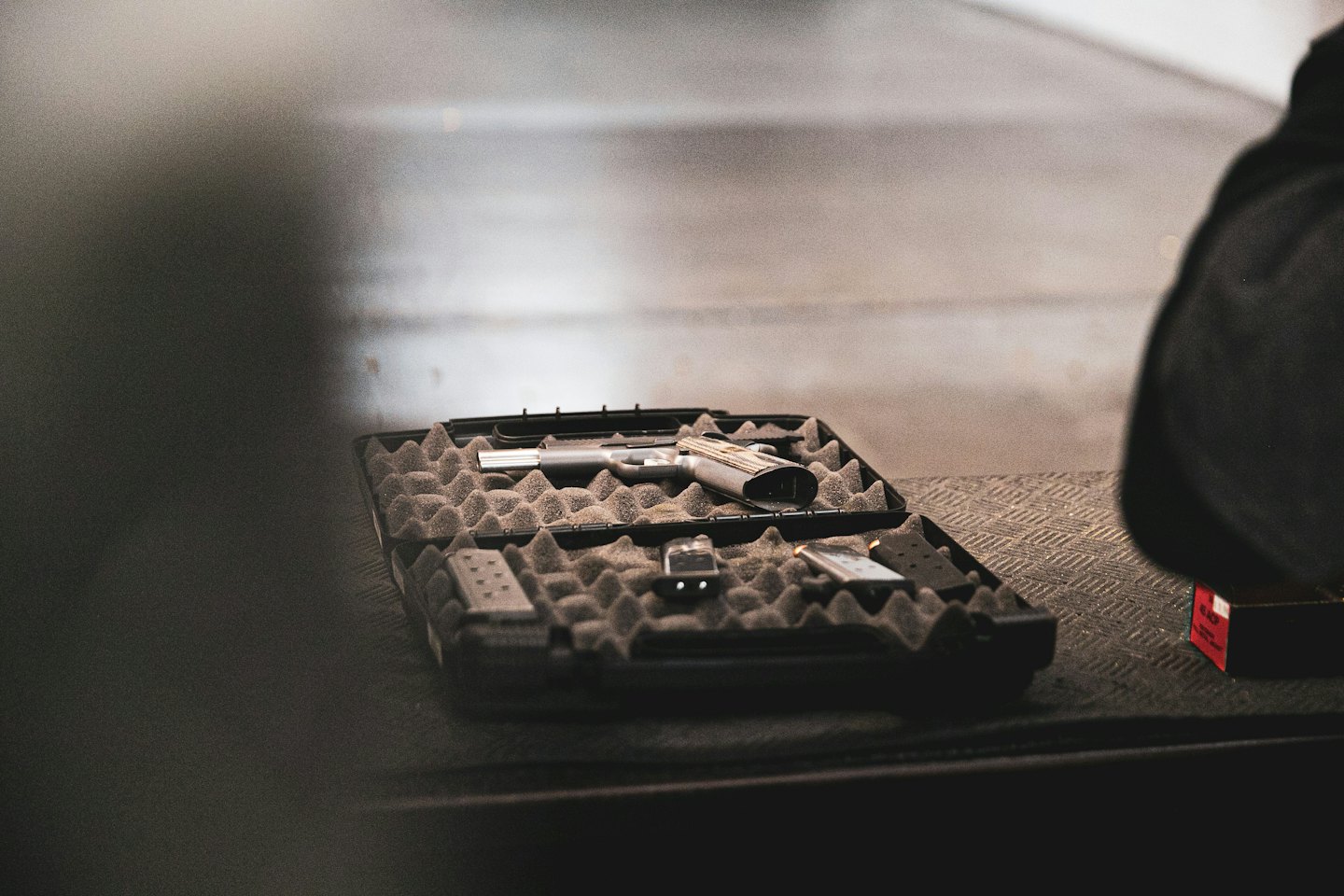 A handgun and magazines sit inside a foam padded case.